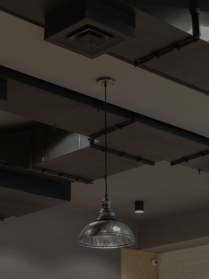 Close-up of an industrial-style ceiling light in a modern indoor setting, emphasizing minimalist design.